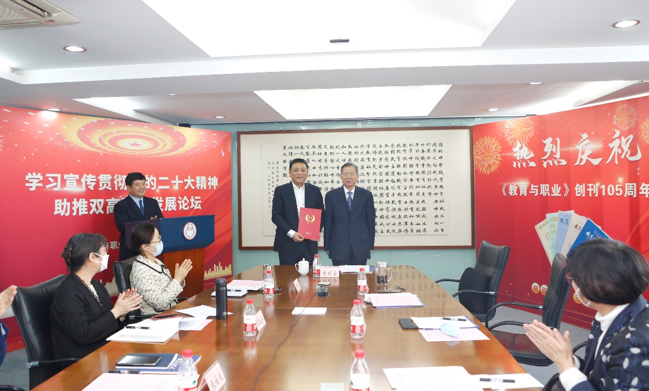 郝明金為《教育與職業》雜志編委代表陳曉明頒發聘書。中華職教社供圖