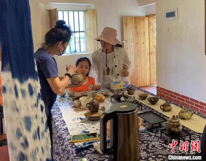 圖為：游客正在咨詢臺灣柴燒作品。　葉秋云 攝