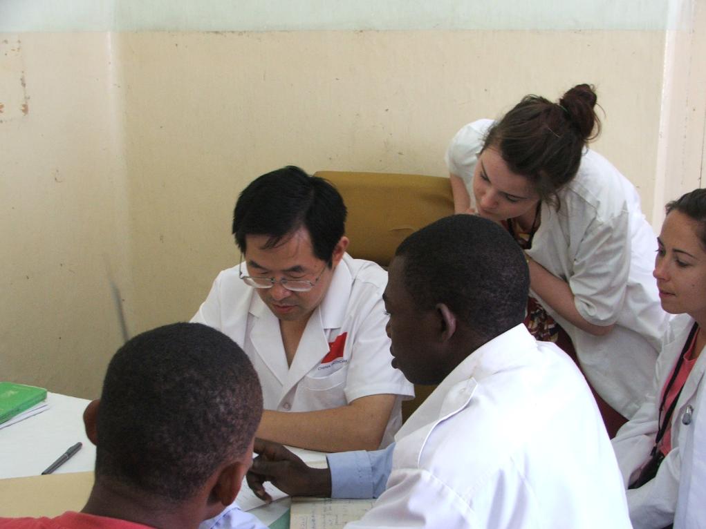 2011年7月22日，在坦桑尼亞桑給巴爾納茲莫加醫(yī)院外科門(mén)診，中國(guó)第24批援桑給巴爾醫(yī)療隊(duì)隊(duì)長(zhǎng)盧建林為當(dāng)?shù)鼗颊咴\治并帶教實(shí)習(xí)生。新華社發(fā)（國(guó)家衛(wèi)生健康委供圖）
