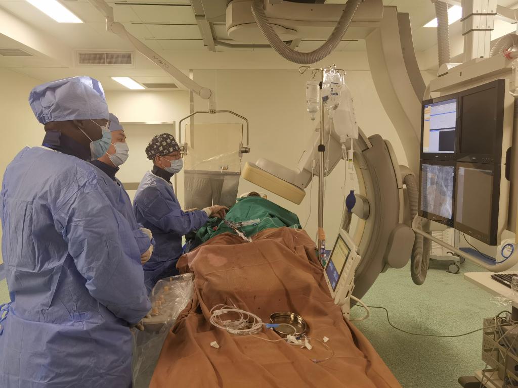 中國(guó)第29批援幾內(nèi)亞醫(yī)療隊(duì)隊(duì)員、首都醫(yī)科大學(xué)附屬北京天壇醫(yī)院心內(nèi)科副主任醫(yī)師王汝朋（右一）正在給患者做手術(shù)。（北京天壇醫(yī)院供圖）