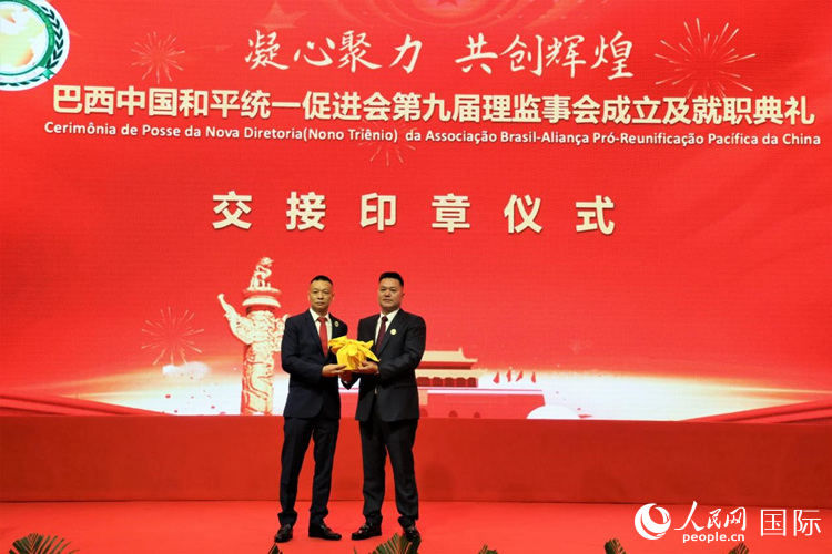 就職典禮中，巴西和統會第七屆和第八屆會長王俊曉與新任會長張小春交接印章。人民網記者 時元皓攝