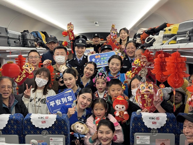 春節期間，在中老鐵路磨萬（磨丁—萬象）段，鐵路客運員工與乘客合影留念。李加勇攝