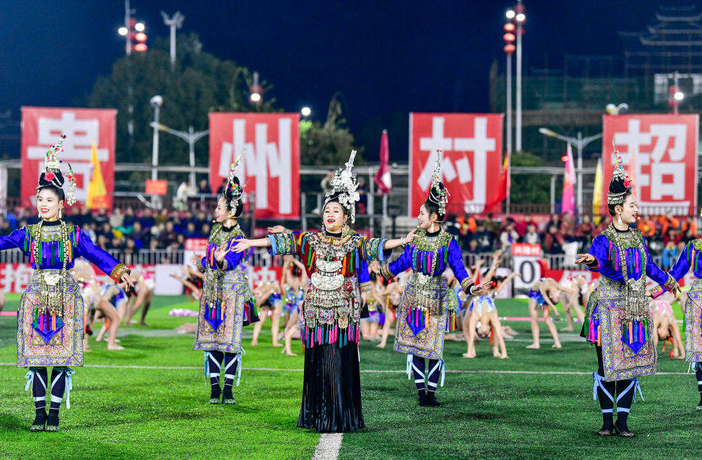 2025年3月14日，2025年貴州“村超”40強交叉賽在榕江“村超”足球場舉行，演員在比賽間隙表演侗族大歌，民族文化伴隨著體育賽事成功“出圈”。圖片來源：新華社