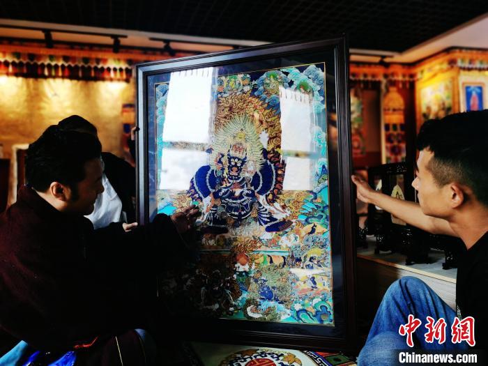 圖為久美尖措(左)與徒弟們展示唐卡作品。　張添福 攝