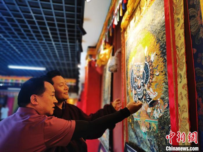 圖為久美尖措展示唐卡作品。　張添福 攝