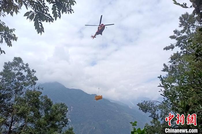直升機起飛將搶修塔材運往海拔1950米的110千伏唐下線29號塔位?！⌒鞈c明 攝
