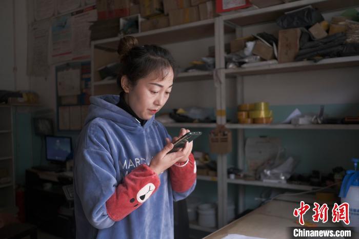 正在快遞站點(diǎn)內(nèi)忙碌的楊莉春。　何蓬磊 攝