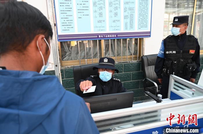 圖為移民管理警察登記完身份信息后將證件歸還給行人。　趙朗 攝