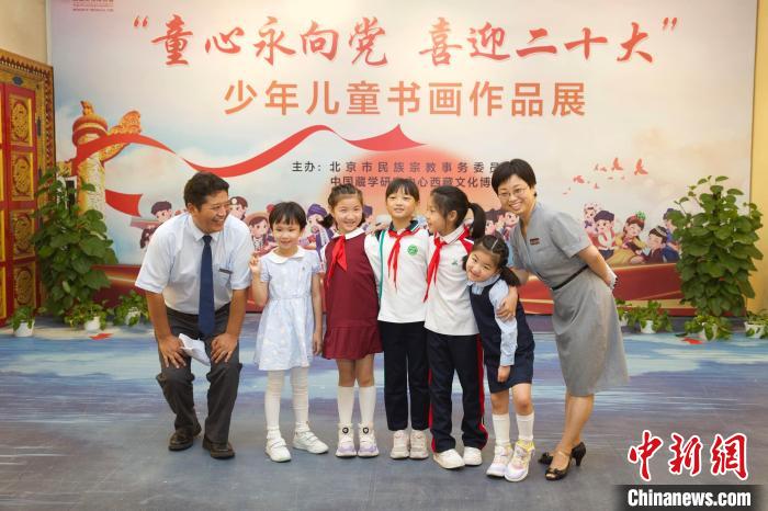 圖為與會嘉賓與入選畫作的“小作者”們在展覽上合影。　中國藏學研究中心供圖