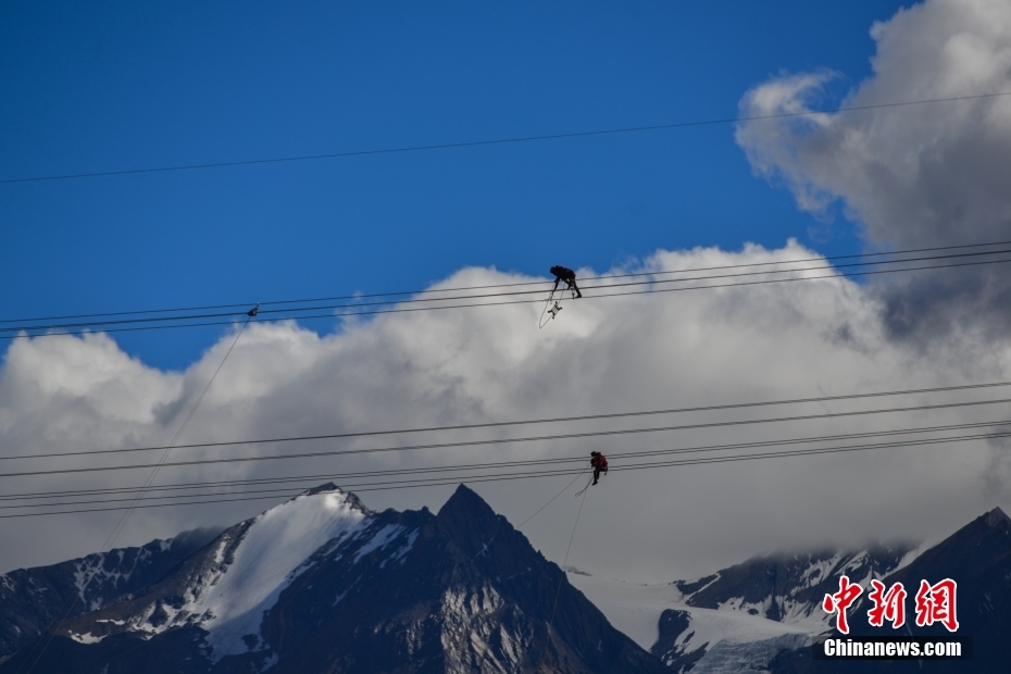 資料圖為2020年6月23日，西藏阿里聯(lián)網(wǎng)工程施工人員在日喀則希夏邦馬雪山附近進行走線作業(yè)，安裝絕緣設備。 <a target='_blank' href='/'><p  align=
