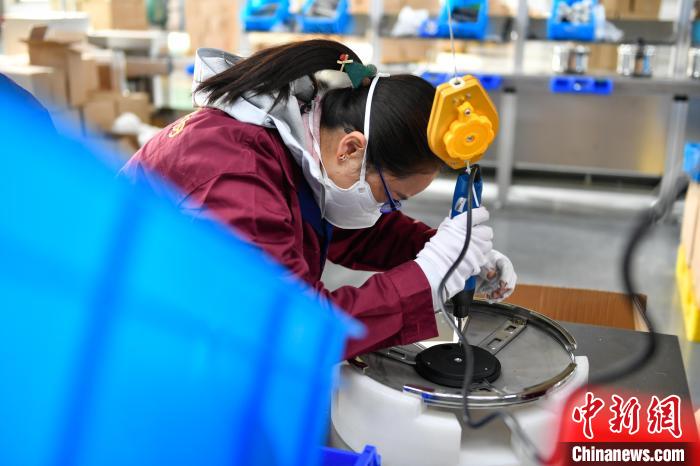 圖為工人正在組裝炊具。　貢嘎來松 攝