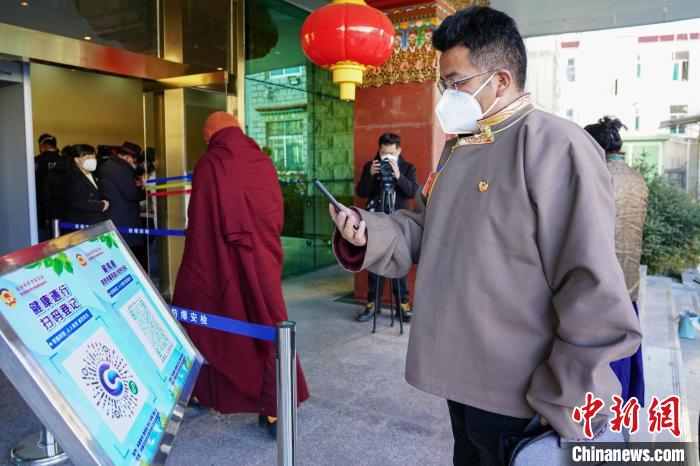 圖為政協委員掃場所碼進入會場。　江飛波 攝