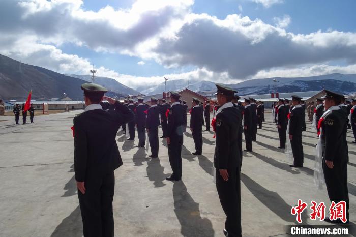 雪山下，退役士兵向軍旗敬軍禮。　李學文 攝