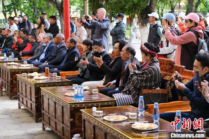 5月19日，中外嘉賓在羅布林卡和游客一起觀看藏戲?！〗w波 攝