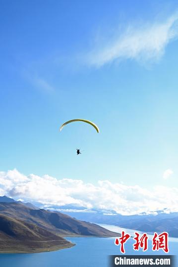 圖為在羊卓雍錯(cuò),游客體驗(yàn)高空滑翔。 趙朗 攝